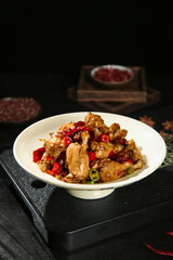 Spicy Stir-Fried Frog Legs with Red Peppers Chinese Cuisine Dish on Dark Slate Board