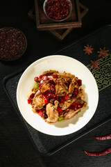 Spicy Chinese Stir-Fry Dish with Red Chilies and Meat on Traditional Dark Wood Background