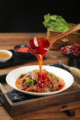 Spicy Red Chili Oil Pouring Over Tripe Dish - Traditional Asian Hotpot Cuisine on Wooden Tray