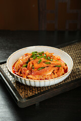 Cold Spicy Beef Tripe Dish Served in White Bowl with Chili Sauce and Green Onions on Bamboo Tray