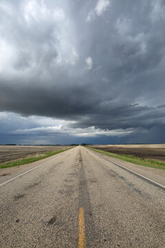 A country highway leading off into a summer storm.