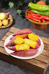 Fresh Roasted Sweet Potatoes with Colorful Vegetables and Groundnuts on Rustic Wooden Table