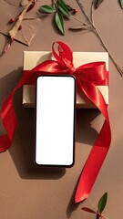Craft Paper Gift Box Tied with a Shiny Red Ribbon and a Blank White Screen Phone Display Set on a Brown Surface with Holiday Accents Overhead