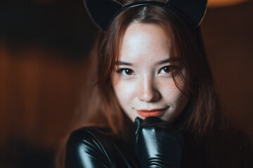 Sleek leather outfit contrasts with playful cat ear headband, ex