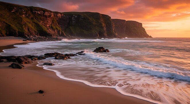 Coastal landscape featuring cliffs ocean waves and a vibrant sunset sky