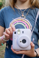 Little girl outdoors on a sunny day with film camera closeup 