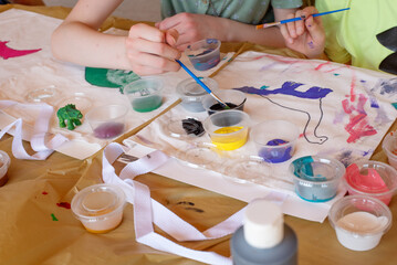 Kids art class painting creatively on canvas totes for birthday party activity 