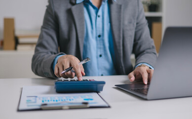 Businessman analyzing digital financial charts and growth trends on laptop, emphasizing the role of technology and data analytics in modern market research and business planning strategies.