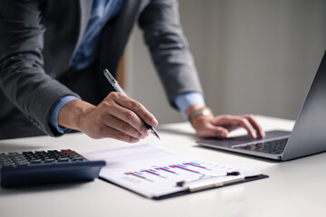 Businessman analyzing digital financial charts and growth trends on laptop, emphasizing the role of technology and data analytics in modern market research and business planning strategies.