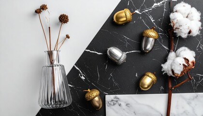 Cotton stems and metallic mini pumpkins on black marble