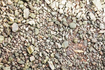 Background of rocks at the river mouth. Pebbles background.stone wall texture. Crushed stone and multi-colored stones close-up.