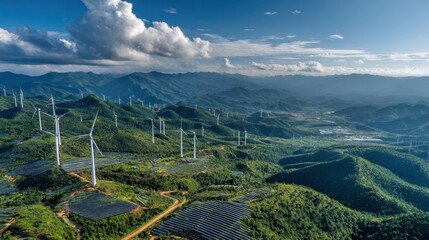 Scenic landscape featuring wind turbines on rolling green hills under a partly cloudy sky