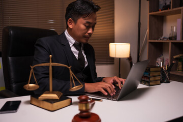 A lawyer is reading a book about law in the office.
