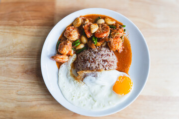 Delicious Stir-fried shrimp with chili, fried egg and brown rice as Thai food close-up