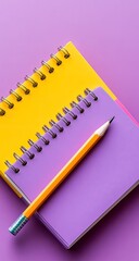 Stacked colorful notebooks with a pencil