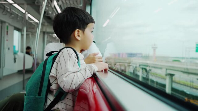 Asian woman and child boy watching skytrain arrive, smiling and feeling excited during travel, sharing family moment while waiting on platform