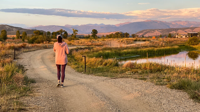Woman Walking on Path in Granby Colorado and Rocky Mountains at Sunset