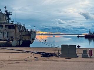 A military ship in the foreground at the Port of Bar, Montenegro, with a dramatic stormy sunset...