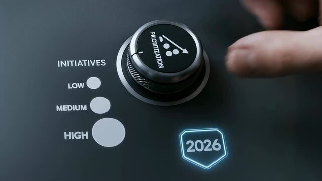 Business hand adjusting prioritization dial to high for 2026 goal achievement, strategic initiative planning, and future business success
