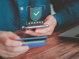 Online payment, data protection, and digital security. A person holds a credit card and smartphone, while a digital shield icon with a checkmark and asterisks shows on the screen. Safe transactions.