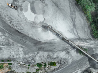 Aerial view of granite and limestone crushing plant with excavators processing raw stone into construction aggregates for concrete and infrastructure development. Stone mill factory.