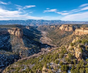 Majestic canyon landscape with snow dusted pines under expansive blue sky