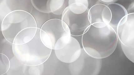 An ethereal abstract background of floating transparent bubbles and soft glowing bokeh lights on a gentle grey backdrop