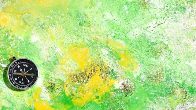 Classic round compass on green yellow texture background. The concept of tourism with a compass. travel, Vacation or outdoor activities with a compass. Colorful pattern. View from above.