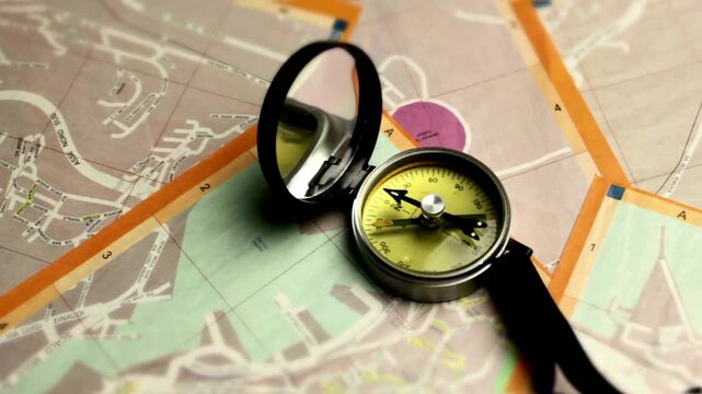 conceptual of global travel, tourism and exploration. searching direction with a compass on background of map. Closeup of compass on the map. Looking on map and compass to checking position. - Powered by Adobe