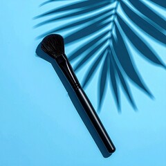 Makeup brush on light blue with palm frond shadow