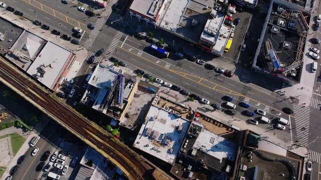 Aerial view of Coney Island Stillwell Avenue subway terminal, residential and commercial buildings, and surrounding city streets with Kaiser Park visible in the distance.