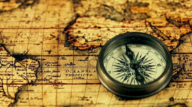 Old vintage retro compass on ancient map background. Antique bronze emblem compass on ancient world map. Travel geography navigation concept background. Old compass over ancient map.