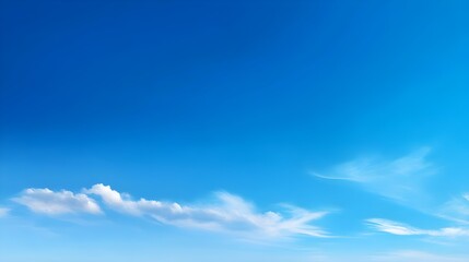 Obraz premium Vast expanse of clear blue sky with soft white clouds drifting gently creating a serene and peaceful atmosphere perfect for summer days and outdoor adventures