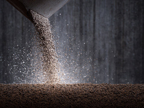 Concrete slump test at site shows fresh aggregate pouring with dust particles flying in air under soft light