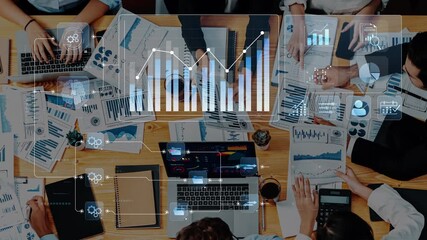 A diverse team collaborates in a modern office setting, analyzing data through digital screens and printed reports. The scene captures innovation and teamwork in action. Raster - Powered by Adobe