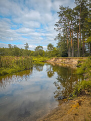 A small river and the surrounding landscape, exemplified by the Grabia River, Poland.