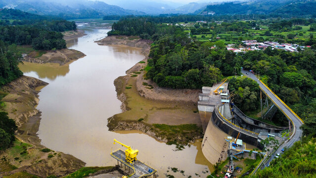 Aerial view of hydroelectric dam and reservoir with low water levels in a mountain landscape