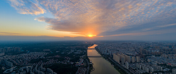 Suizhou City Hubei Province China river sunset shows clouds over a vast urban landscape.