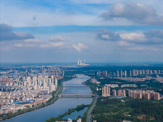 Suizhou City Hubei Province China view shows a large river flowing through the urban landscape with tall buildings lining the banks under a cloudy blue sky.