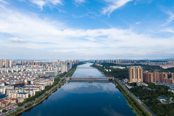 Suizhou City, Hubei Province, China presents a vast river flowing through its urban landscape under a bright sky.