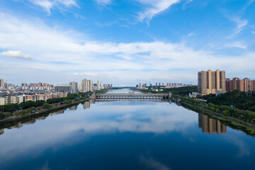 Obraz premium Suizhou City, Hubei Province, China panorama showcasing a wide river reflecting the sky and city buildings.