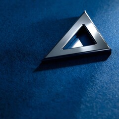 Shiny Silver Metallic Triangle on Dark Blue Textured Background with Dramatic Lighting
