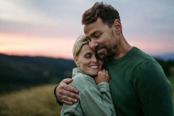 Portrait of romantic couple in nature during sunset.