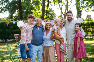Grandparents, parents and children posing together at family celebration
