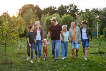 Obraz premium Multigenerational family outdoors, on walk, holding hands.