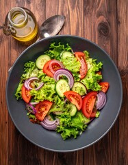 Fresh salad in a dark bowl on a wooden table
