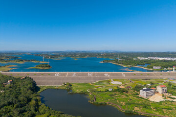 Fototapeta premium Xu Jiahe Reservoir is a vast body of water in Suizhou City, Hubei Province, China, with lush green surroundings and a clear blue sky overhead.
