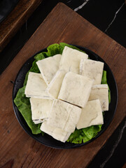 Fresh Tofu Slices on Lettuce Leaves in Iron Plate - Asian Vegetarian Protein Ingredient