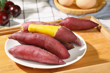 Fresh Purple Sweet Potatoes on White Plate Kitchen Counter Closeup View Healthy Organic Vegetables