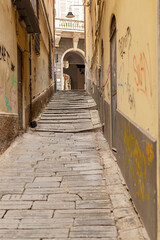Obraz premium Narrow laneway going uphill with pavers and small steps, Genoa